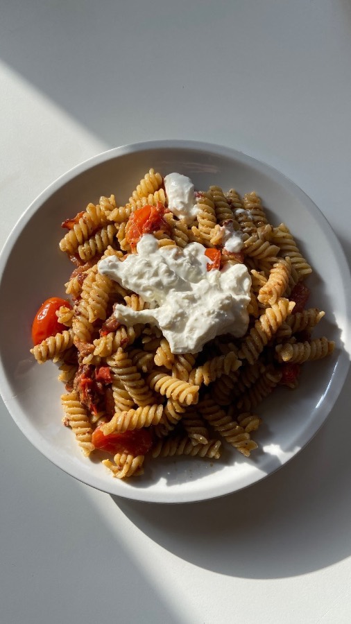 Pasta con pesto di pistacchio, pomodorini, stracciatella e guanciale